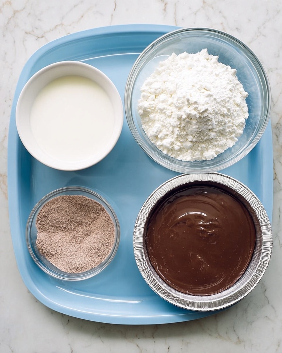A white marbled surface holds a blue tray with four items arranged neatly. On the top left is a small white bowl filled with a white liquid, likely cream or milk. Below it, a clear glass bowl contains a mound of white powder, which looks soft and crumbly. To the bottom right, another clear glass bowl holds a fine brown powder. On the right side of the tray, there is a round aluminum pie pan with a shiny, dark brown, smooth chocolate filling inside. The setup is simple and clean. Photo taken with an iphone --ar 4:5 --v 7