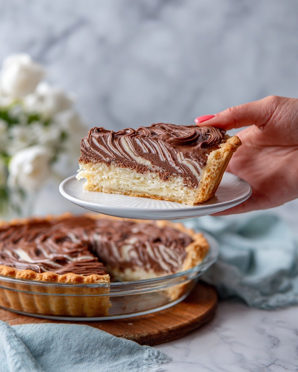 A slice of cake is held above a white plate by a woman's hand. The cake has about ten thin layers with alternating light beige and dark brown stripes inside, showing a zebra pattern. On top, there is a thick, smooth layer of rich dark brown chocolate frosting with soft swirls. The rest of the cake in a clear glass pie dish has one slice removed, showing the same striped pattern inside. The dish is on a wooden board, with a soft blue cloth and white flowers in the background over a white marbled surface. Photo taken with an iphone --ar 4:5 --v 7