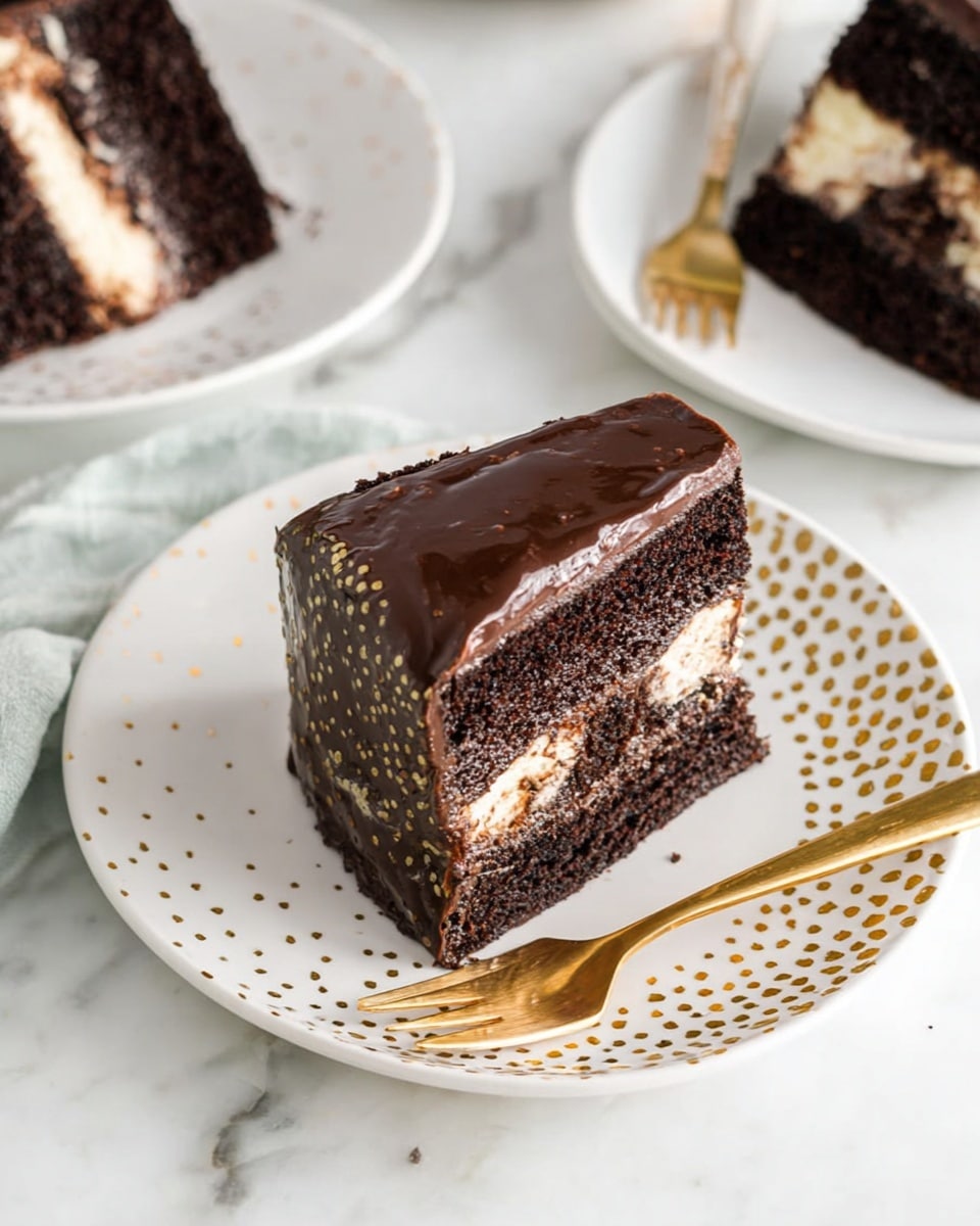 The image shows a slice of chocolate cake on a white plate with gold dots on the right edge. The cake has three layers: two dark chocolate sponge layers on top and bottom, and a lighter cream layer in the middle. The whole cake slice is covered in shiny dark chocolate frosting. Next to the cake on the plate, there is a gold fork. The plate is placed on a white marbled surface, and other slices of cake on similar plates are partially visible in the background. photo taken with an iphone --ar 4:5 --v 7
