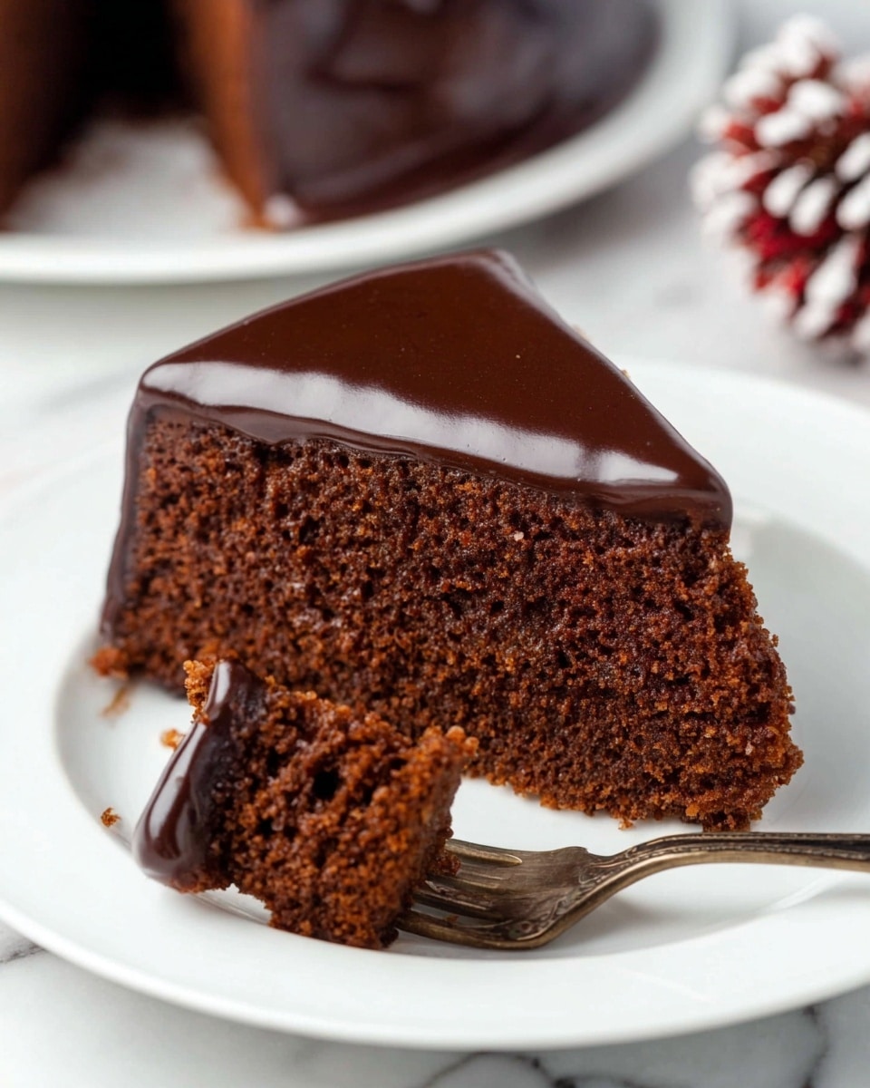 A slice of chocolate cake with one thick layer, showing a rich brown crumb texture and covered around the edges with a shiny dark chocolate glaze. In front of the slice, a fork holds a small bite of the cake with the glossy glaze on top. The cake sits on a white plate placed on a white marbled surface. Photo taken with an iphone --ar 4:5 --v 7
