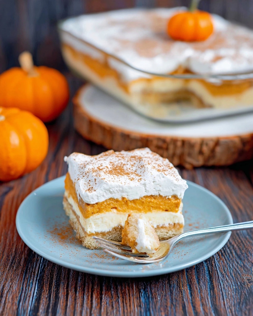 A square piece of layered dessert sits on a white plate with a soft blue tint, featuring three visible layers: a light brown base, a creamy orange middle, and a whipped white topping dusted with brown powder. A fork with a bite-sized piece of the dessert rests on the plate in front of the slice. In the background, the larger dessert is shown in a clear square glass dish placed on a white marbled wooden round board with two small orange pumpkins nearby. The surface beneath everything is a dark wood texture. Photo taken with an iphone --ar 4:5 --v 7