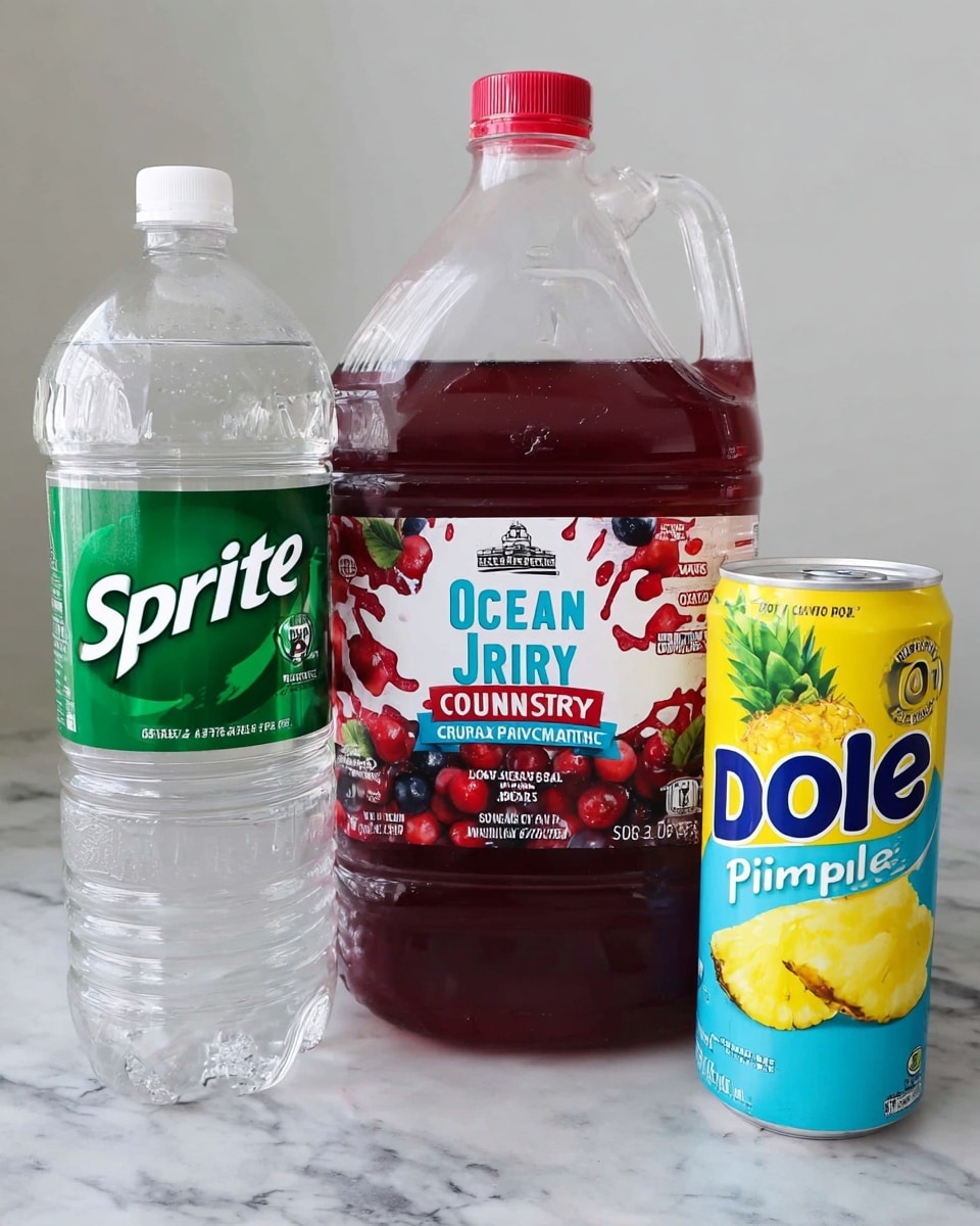 The image shows three large drink containers placed side by side on a white marbled surface. On the left is a clear plastic bottle filled with a clear liquid, with a large green label reading