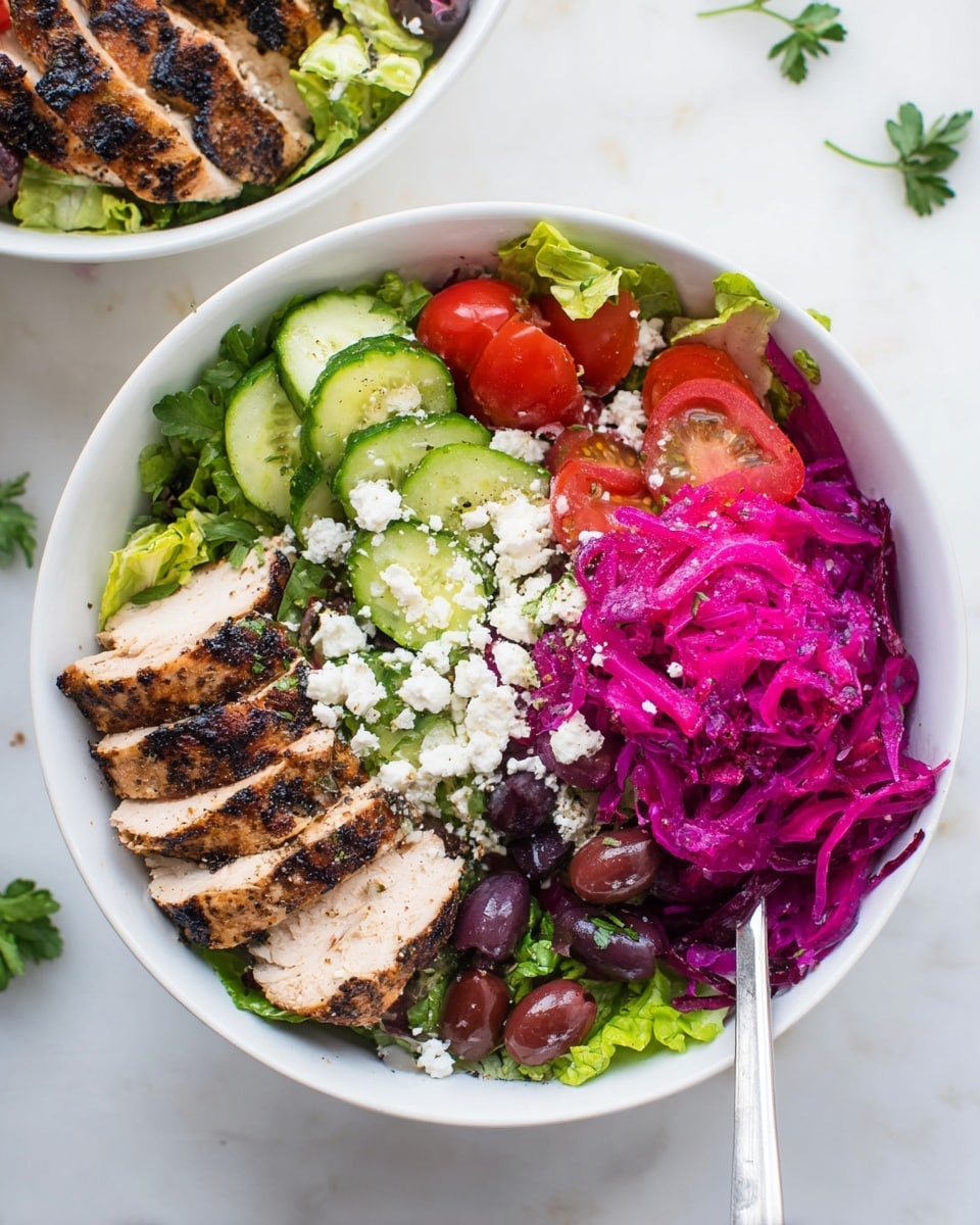 The image shows a white bowl filled with a colorful salad arranged in three main sections. On the left side, there are five slices of grilled chicken, showing dark grill marks and a slightly browned surface. In the middle, bright green lettuce leaves are topped with thick slices of cucumber, red tomato wedges, black olives, and crumbled white cheese, all mixed with small pieces of fresh herbs. On the right side, there is a bright purple shredded ingredient, likely pickled cabbage, adding a vibrant contrast. A white-handled fork rests inside the bowl, and the bowl is set on a white marbled surface with some scattered herbs nearby. photo taken with an iphone --ar 4:5 --v 7