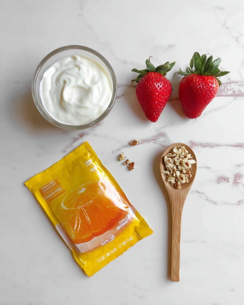 The image shows four ingredients on a white marbled surface: a small clear glass filled with white creamy yogurt, a yellow packet with an orange jelly picture on it, two fresh red strawberries with green leaves, and a wooden spoon holding a mix of crushed nuts in beige and brown tones. The items are neatly arranged with the yogurt glass near the top left, the packet below it, the two strawberries side by side on the right, and the wooden spoon placed diagonally with the handle pointing downward. Photo taken with an iphone --ar 4:5 --v 7