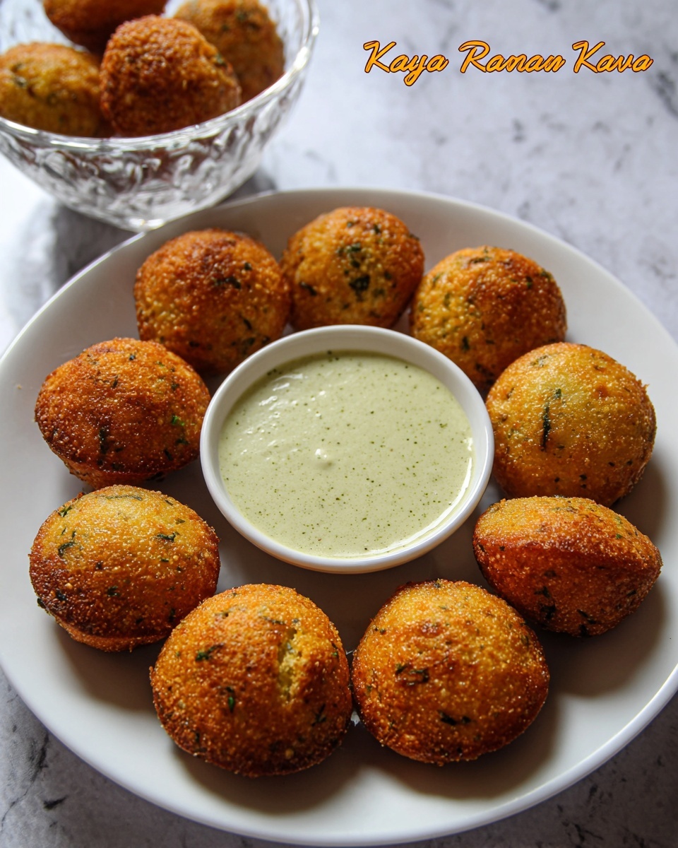 The image shows a white plate with eight golden-brown, round Rava Kara Paniyaram arranged in a circle. Each paniyaram has a crispy texture with small green and black specks visible on the surface. In the center of the circle is a small bowl filled with light green dipping sauce, smooth in texture. Behind the plate, there is a clear glass bowl with more paniyarams stacked inside. The background is a white marbled texture. Photo taken with an iphone --ar 4:5 --v 7