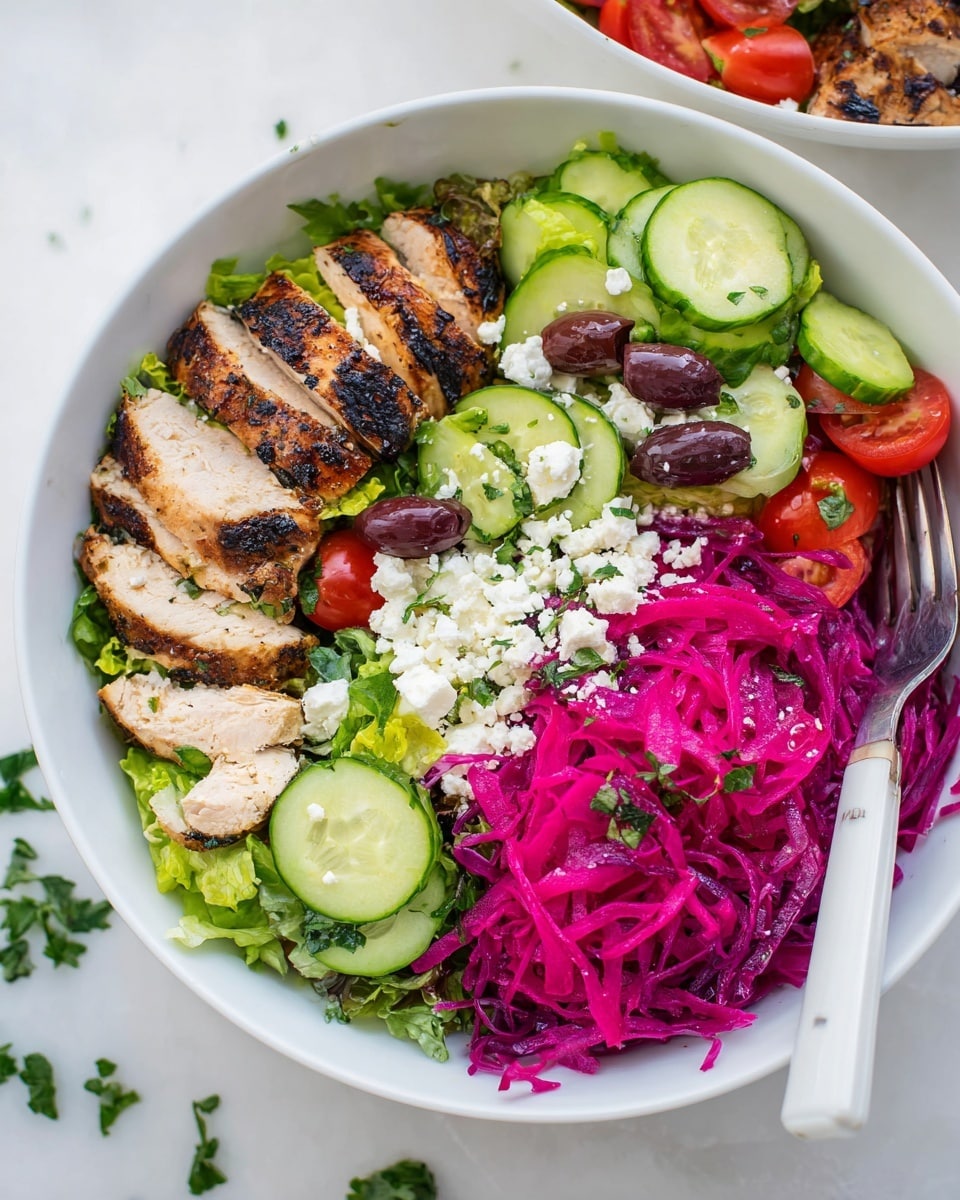 A white bowl with four main parts: the front left has sliced grilled chicken with visible golden brown grill marks and herbs; next to it on the right is a bright purple shredded cabbage; the back left contains a fresh mix of green lettuce, diced red tomatoes, olives, and crumbled white cheese; the ingredients are arranged neatly and the bowl rests on a white marbled surface with a fork and knife nearby, the focus is on the front bowl with another similar bowl blurred in the background. photo taken with an iphone --ar 4:5 --v 7