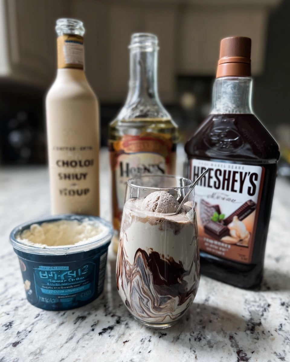 The image shows a clear glass filled with a creamy drink topped with swirls of dark chocolate syrup creating a marbled effect inside the glass. Behind the glass, there are three bottles standing on a white marbled countertop: a tall bottle with a light beige label, another tall bottle with a medium brown label, and a large bottle of Hershey's chocolate syrup with a dark brown label and cap. In front of the bottles, a half-opened ice cream tub with a dark blue lid reveals creamy ice cream inside. The scene is lit softly, emphasizing the rich textures and colors of the ingredients. Photo taken with an iphone --ar 4:5 --v 7
