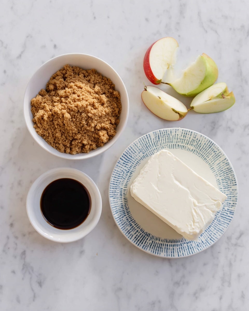 The image shows four main food items placed on a white marbled surface. On the left, a white bowl is filled with crumbly brown sugar. Below it, a small white bowl contains a dark liquid, likely vanilla extract. To the right, a white plate with a subtle blue pattern holds a solid block of cream cheese with a smooth, slightly uneven surface. Above the plate, there are apple pieces, including one large half and two smaller cut parts, showing pale cream flesh and light green and red skin. Photo taken with an iphone --ar 4:5 --v 7
