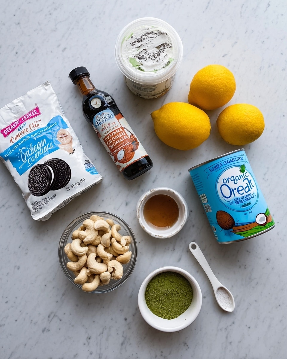 The image shows various baking ingredients arranged on a white marbled surface. There is a pack of gluten-free double-stuffed Oreo cookies in white packaging with blue and pink accents on the bottom left. Above it is a small bottle of organic bourbon vanilla extract with a dark brown label. Next to that is a container of vegan cream cheese with a white lid and a blue and green label. To the right are two yellow lemons placed side by side. Further to the right is a can of organic coconut cream with a blue label featuring a coconut image. In front of the can is a glass measuring cup filled with soaked cashews. Below the cashews are two small white bowls, one containing green matcha powder and the other filled with brown sugar. A white measuring spoon with brown liquid sits near these bowls. photo taken with an iphone --ar 4:5 --v 7