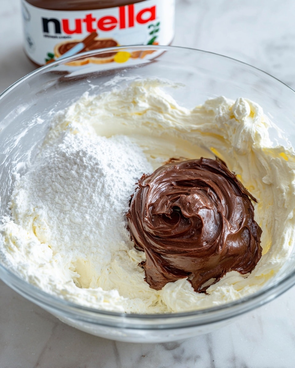 A clear glass bowl with three layers of ingredients sitting on a white marbled surface is shown. The first layer around the bowl is a thick, creamy white mixture with fluffy texture, covering the sides of the bowl. In the center, there is a thick, rich dark brown chocolate spread with a shiny, smooth look and swirl marks on top. To the left of the chocolate spread is a small pile of white powder, likely powdered sugar, contrasting with the creamy and chocolate layers. The background includes a Nutella jar slightly blurred. Photo taken with an iphone --ar 4:5 --v 7