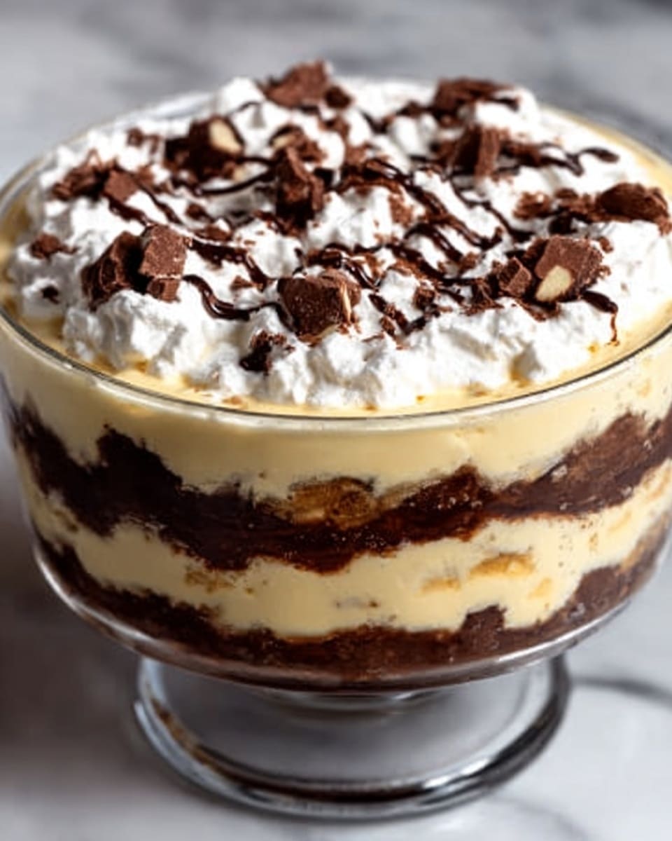 The image shows a clear glass bowl with a layered dessert. At the bottom, there is a dark brown chocolate layer with a dense texture. Above that, there is a creamy pale yellow layer that looks smooth and thick. On top of this creamy layer, there is another thin dark brown chocolate layer with some texture. The top layer is white whipped cream, spread evenly around the edges and topped with small pieces of chocolate and a drizzle of chocolate sauce. The bowl is placed on a white marbled surface. Photo taken with an iphone --ar 4:5 --v 7