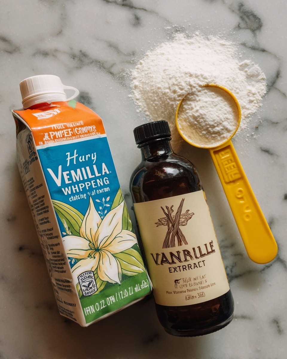 The image shows three items placed on a white marbled surface: a carton of heavy whipping cream with a white cap and orange, green, and blue design, a dark amber bottle labeled