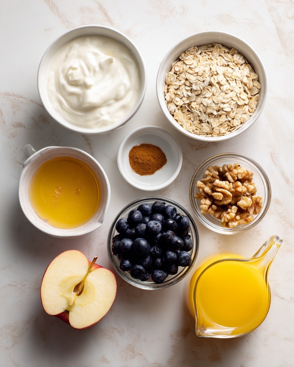 The image shows eight separate ingredients arranged on a white marbled surface: a white bowl filled with creamy white yogurt in the top left, a white bowl of light beige rolled oats next to it, a small white bowl with a small heap of brown cinnamon powder, a white bowl with golden honey, a glass bowl filled with dark blue blueberries, a halved red apple with yellow flesh placed center, a small white bowl of light brown walnut pieces, and a clear glass pitcher holding bright yellow orange juice. All bowls are white except the yogurt one, which is mustard yellow. Photo taken with an iphone --ar 4:5 --v 7