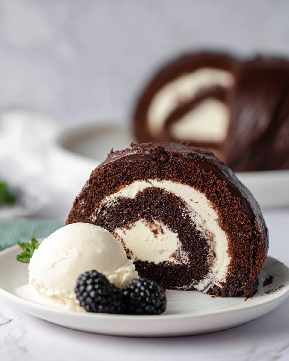A slice of dark chocolate cake roll with a smooth, creamy white filling swirled inside is placed on a white plate. The cake has a rich, moist texture with a glossy chocolate coating on the outside. Next to the slice, there is a scoop of white ice cream with a soft texture and a fresh blackberry in front of it on the plate. In the background, the rest of the cake roll is blurred but visible on a white plate, all placed on a white marbled surface. The photo taken with an iphone --ar 4:5 --v 7
