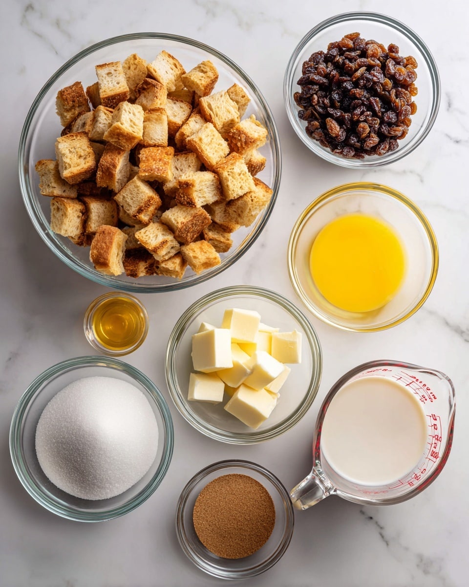 The image shows eight clear glass containers on a white marbled surface, each holding different ingredients for a recipe. Starting from the bottom left, there is a large bowl filled with cubed, toasted bread pieces that are golden brown on one side and white on the other. Above it is a smaller bowl full of dark brown raisins. To the right of the bread, in order, are a bowl of white granulated sugar, a bowl with beaten yellow eggs, a bowl of melted yellow butter, a small bowl of light brown sugar, a small bowl with brown cinnamon powder, and a glass measuring cup filled with white milk, showing red measurement markings. The setup is clean and organized, ready for mixing. photo taken with an iphone --ar 4:5 --v 7