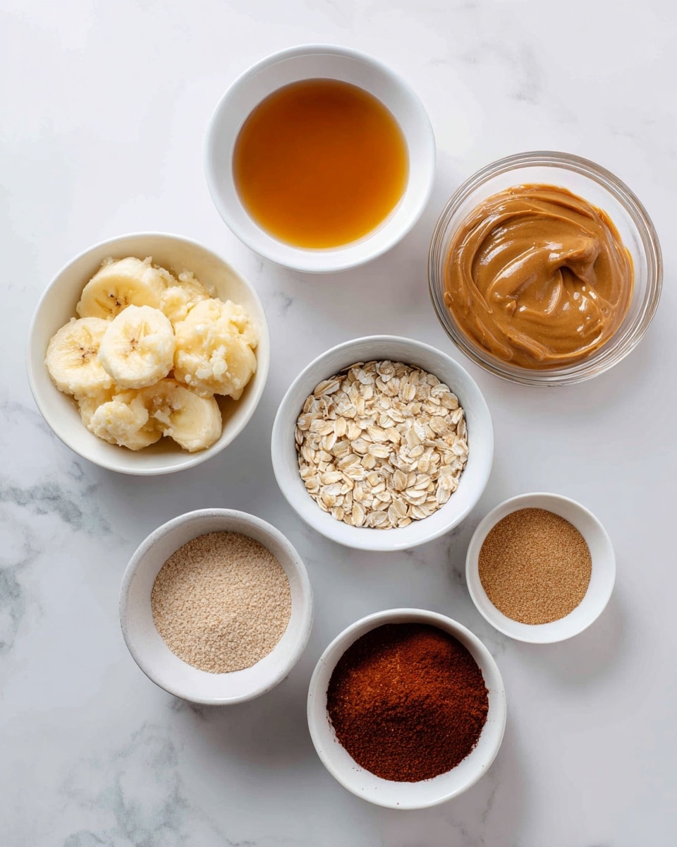 Seven small bowls are placed on a white marbled surface, each filled with different ingredients. In the top left, there is a white bowl with a golden-brown liquid, next to it on the right a white bowl with light brown creamy peanut butter, and on the far right, a clear glass bowl filled with golden brown sugar. Below these, on the far right, a clear glass bowl contains light beige rolled oats. To the left of that, a white bowl holds mashed bananas with a soft, slightly lumpy texture. Below the liquid bowl to the left, a white bowl contains light brown powder, and beside it to the right, a very small white bowl is filled with ground cinnamon or similar spice in a deep reddish-brown hue. The overall scene is bright and clean, arranged neatly for ingredient display, photo taken with an iphone --ar 4:5 --v 7